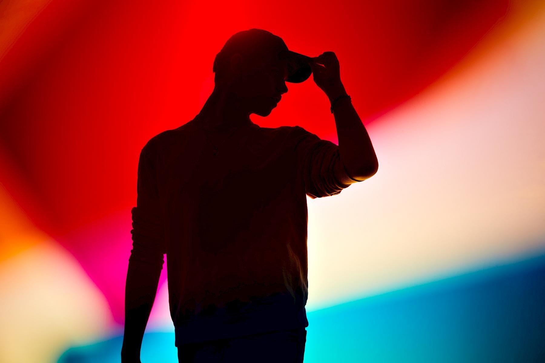 Silhouette of Jan against a colourful light play. Portrait for NZZ am Sonntag