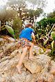 A boy climbing a rock barefoot